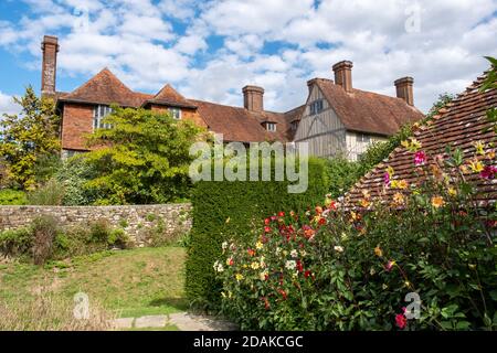 Great Dixter House and Garden, Northiam, East Sussex, Inghilterra, Regno Unito, GB. Dahlias colorati piantati intorno agli annessi. Foto Stock
