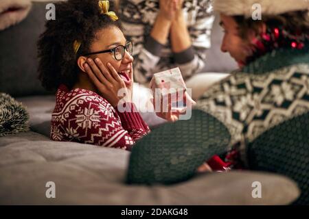 giovane femmina afro-americana sorprendo dal presente da un amico Foto Stock