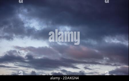 Nuvole al tramonto. Drammatico magico paesaggio di alba su blu grigio colore cielo nuvoloso Foto Stock