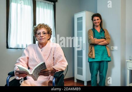 Paziente anziano in posa con il medico sullo sfondo Foto Stock