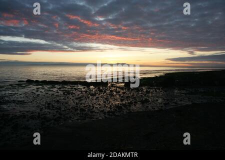 Sunset Croy Shore Carrick, Ayrshire, Scozia, Regno Unito. Il tramonto sull'isola di Arran e Firth of Clyde sulla costa occidentale della Scozia come visto dalla spiaggia di Croy Foto Stock