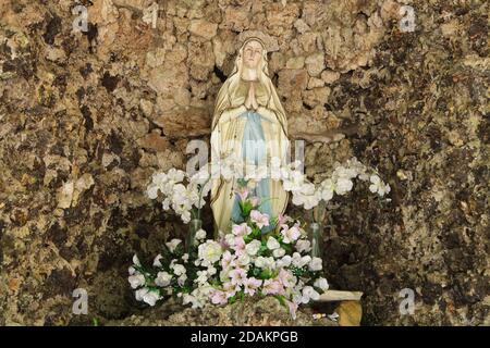 Statua di nostra Signora di Lourdes sull'altare principale nella cappella di roccia nella Modlivý důl (Valle di preghiera) vicino Svojkov nelle montagne Lusaziane nella Boemia settentrionale, Repubblica Ceca. La cappella di roccia è dedicata alla Madonna di Lourdes. Foto Stock