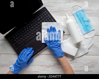 Disinfezione del computer portatile per proteggersi da batteri e virus, rimanere a casa, lavorare in remoto. Foto Stock