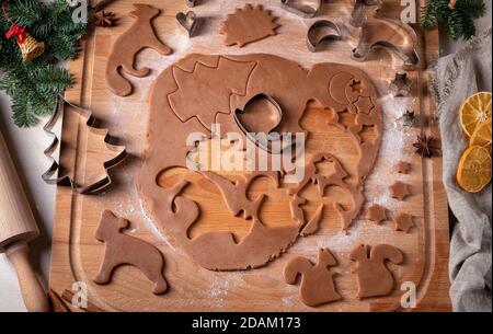 Preparazione di biscotti natalizi fatti in casa con pan di zenzero - taglio delle forme dall'impasto Foto Stock