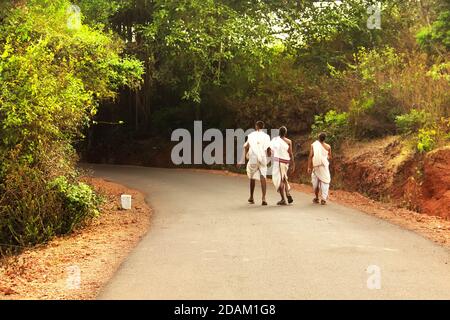 Tre monaci che camminano sulla strada. Gokarna, Karnataka, India. Foto Stock