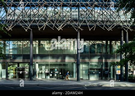 Uomo con una maschera che cammina di fronte a Buildings Avenue De France Parigi 13 Foto Stock