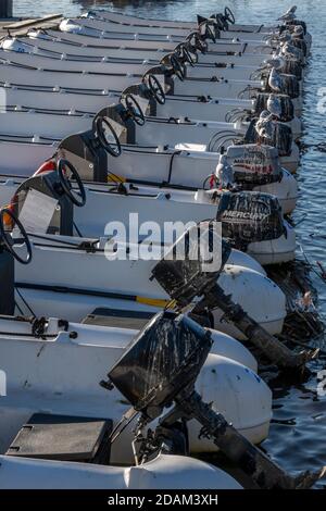 una fila di noleggio barche da diporto su un molo nel porto di christchurch coperto di gabbiano poo. Foto Stock