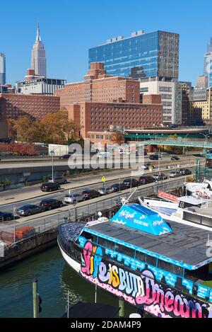 Barche a Skyport Marina, con la FDR Drive, Midtown Manhattan e l'Empire state Building sullo sfondo Foto Stock