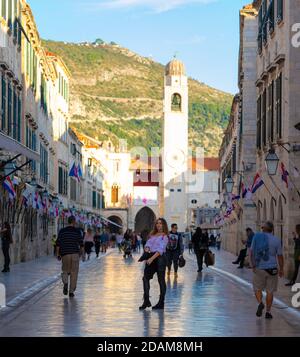 Dubrovnik Croazia Novembre 2020 Brunette si trova nel mezzo della via Stradun nella città vecchia di Dubrovnik, in posa come molte persone a piedi. Foto Stock