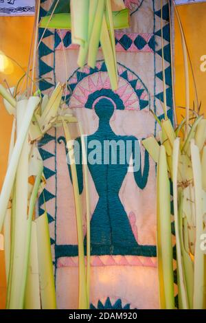Tessuto balinese ricamato avvolto intorno alla base delle offerte del tempio per il festival di Galungan, Ubud, Bali, Indonesia. Dewi Sri - motivo della Dea del riso. Foto Stock