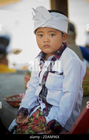 Ragazzo balinese in abbigliamento tradizionale che frequenta un tempio locale per l'inizio del festival di Galungan. Vicino a Ubud, Bali, Indonesia Foto Stock