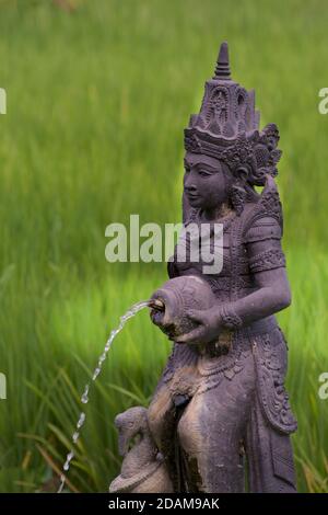 Fontana d'acqua di Dewi Sri. Dea Balinese di riso. Campo di riso dietro. Ubud, Bali Foto Stock