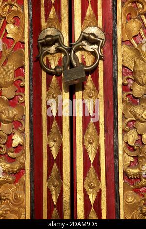 Porta dipinta in oro e rosso con lucchetto in un tempio indù, vicino a Ubud, Bali, Indonesia Foto Stock