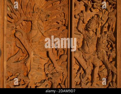 Intricate sculture in legno sulle porte del tempio raffiguranti scene della mitologia indù, Ubud, Bali, Indonesia Foto Stock