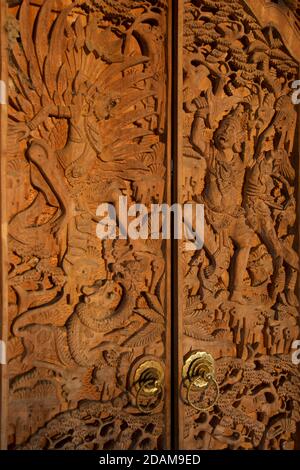 Intricate sculture in legno sulle porte del tempio raffiguranti scene della mitologia indù, Ubud, Bali, Indonesia Foto Stock