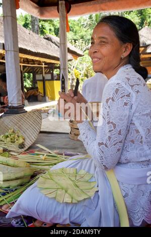 Donna balinese che lapida piccoli cesti per offerte religiose al complesso del tempio Gunung Kawi, Tampaksiring, Bali, Indonesia Foto Stock