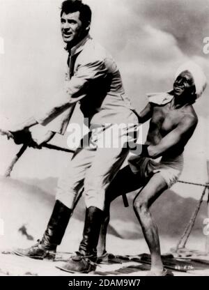 DATA DI USCITA: 17 febbraio 1939 TITOLO: Gunga DIN STUDIO: RKO radio Pictures REGISTA: George Stevens TRAMA: I sergente dell'esercito britannico Ballantine (Douglas Fairbanks Jr.), Cutter (Cary Grant) e MacChesney (Victor McLaglen) servono in India durante il 1880, insieme al loro alfiere nativo, Gunga DIN (Sam Jaffe). Mentre completano una pericolosa missione di riparazione dei telegrafi, dissotterrano le prove del culto soppressa di Thuggee. Quando Gunga DIN racconta ai sergente di un tempio segreto fatto d'oro, il Cutter per la caccia alle fortuna viene catturato dai Thuggees, e spetta ai suoi amici salvarlo. CON LA STELLA: Foto Stock