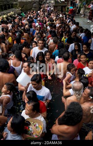 Indonesiani nel bagno rituale di purificazione a Tirta Empul, Bali, Indonesia Foto Stock