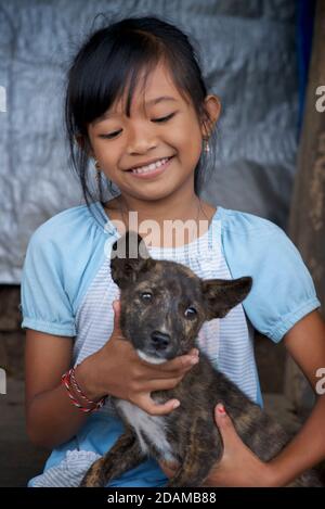 Ritratto di una ragazza indonesiana con il suo cucciolo. Bali, Indonesia Foto Stock