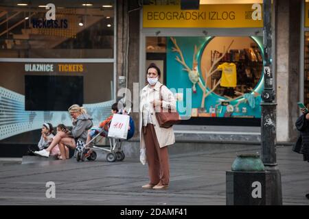 BELGRADO, SERBIA - 10 OTTOBRE 2020: Anziana donna anziana che indossa una maschera respiratoria in piedi in via Kneza Mihailova di Belgrado, durante il coron Foto Stock