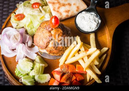 Agnello Gyros kebab servito con pane, patatine fritte e insalata e. Tzatziki Foto Stock