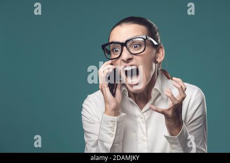 Arrabbiato ha stressato businesswoman gridando al telefono, è nervoso e deluso Foto Stock