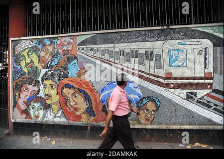 21.02.2011, Kolkata (Calcutta), Bengala Occidentale, India, Asia - UN uomo cammina davanti a un mosaico di piastrelle colorate fuori da una stazione della metropolitana. Foto Stock