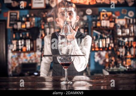 Il barman mescola un cocktail al bar Foto Stock