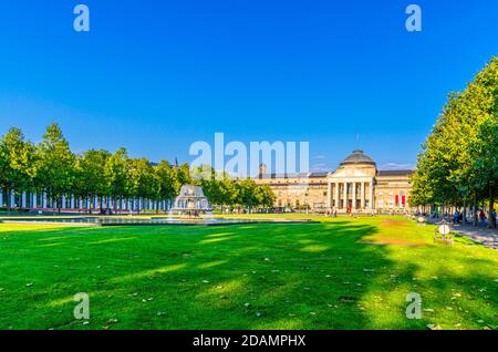 Wiesbaden, Germania, 24 agosto 2019: Kurhaus o curativo casa spa e casinò edificio e Bowling Green parco con prato erboso, vicolo alberi e stagno con fontana nel centro storico della città, stato di Assia Foto Stock