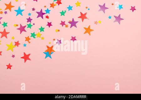 sfondo multicolore di stelle colorate confetti su sfondo rosa. Foto Stock