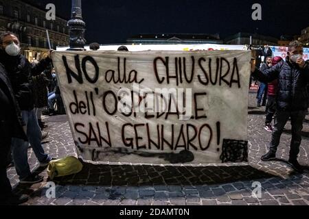 Covid 19 - il fallimento di un sistema di Napoli.dimostrazione unitaria di diversi movimenti in Piazza Plebiscito, presieduta da un imponente esercito di forze dell'ordine. «per il sostegno sanitario ed economico di ogni ricchezza ai ricchi». Questo è lo striscione esposto da circa cento manifestanti di fronte all'ingresso della Prefettura di Napoli, in Piazza Plebiscito. I dimostranti hanno acceso un po' di fumo rosso. Un'altra bandiera reca l'iscrizione «No alla chiusura dell'ospedale di San Gennaro». L'ingresso al Palazzo del Governo e' sorvegliato dalla polizia in equipaggiamento da sommossa. (Foto di Alessandro Barone/Pacific Foto Stock