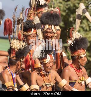 Un gruppo di tribisti di Naga che si siedono indossando il loro abbigliamento tradizionale iat un villaggio a Nagaland India il 4 dicembre 2016 Foto Stock