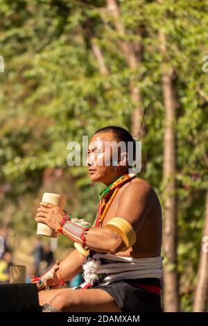 Un tribesman di Naga vestito in abito tribale che beve da a. Tazza di bambù a Kohima nagaland India il 4 dicembre 2016 Foto Stock