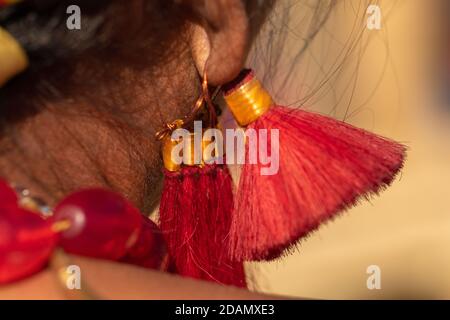 Messa a fuoco selettiva primo piano immagine macro di una tribale tradizionale Orecchini rossi indossati da donne Naga Foto Stock