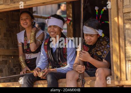 Naga ragazzi e ragazze che si siedono e ridono insieme indossando tradizionale Abbigliamento in Kisama Heritage Village a Nagaland India su 3 Dicembre 2016 Foto Stock