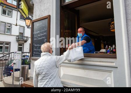 Friburgo, Germania. 13 Nov 2020. Un cliente porta il pranzo ordinato dall'ospite del Goldener Anker Inn in una borsa da portare via. A causa delle restrizioni imposte dai governi federali e statali, i ristoratori sono attualmente in grado di offrire solo cibo e bevande da portare via. Credit: Philippe von Ditfurth/dpa/Alamy Live News Foto Stock