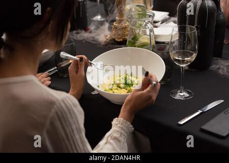Donna che mangia insalata estiva fresca con cavolo di verdure, spinaci, prezzemolo, verdure in ciotola bianca. Cibo sano vegetariano. Foto Stock