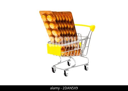 Carrello per la spesa in miniatura pieno di blister di vitamina C. Primo piano, angolo basso, isolato su bianco. Foto Stock