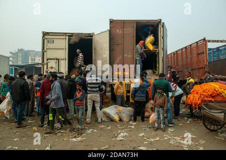 Nuova Delhi, India. 14 novembre 2020. Molte persone sono viste raccolte per acquistare ghirlande di fiori da un camion senza alcun social distancing.A mercato all'ingrosso di fiori a Nuova Delhi durante la pandemia di Covid-19. I fiori sono importanti nei festival indù per la decorazione e l'offerta alle divinità. Credit: SOPA Images Limited/Alamy Live News Foto Stock