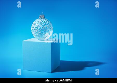 Delicata bella pallina bianca sull'albero di Natale su sfondo blu. Foto Stock