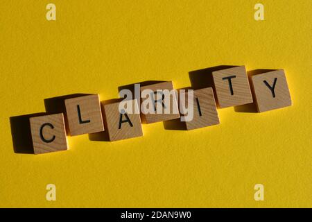 Chiarezza, parola in lettere alfabetiche in legno isolato su sfondo giallo brillante Foto Stock