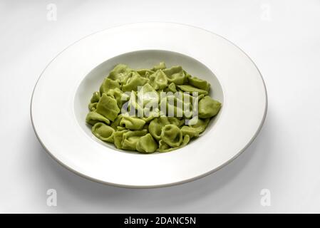 ravioli verdi del plin, pasta delle langhe italia, a base di pasta all'uovo e spinaci su fondo bianco Foto Stock