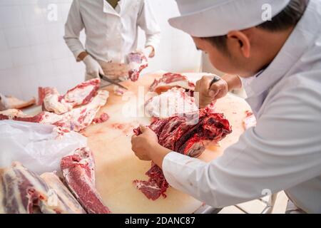 Macellaio asiatico ha tagliato carne cruda di manzo wagyu con un coltello presso il macello, l'industria della carne, manzo Wagyu Foto Stock