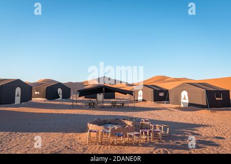 Accampamento nel deserto e falò nelle dune di Erg Chigaga, alle porte del Sahara. Marocco. Concetto di viaggio e avventura. Foto Stock