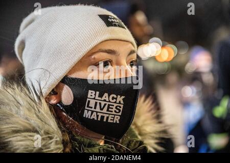 Il protester indossa Black Lives Matter mask durante il marzo.Detroit respirerà, un gruppo attivista contro la brutalità della polizia e per Black Lives, ha organizzato una marcia notturna 'Chief Craig rassegnarsi' nel centro di Detroit. Questa particolare protesta si è concentrata sul trattamento riservato dal capo della polizia James Craig ai manifestanti di destra che sono entrati a Detroit per fermare il conteggio dei voti al TCF Center il giorno dopo le elezioni. Detroit respira asserendo che i loro manifestanti pacifici sono stati inviati all'ospedale dalla polizia di Detroit, mentre i manifestanti di destra sono stati accolti a Detroit. Kevin Saunderson, uno dei Th Foto Stock