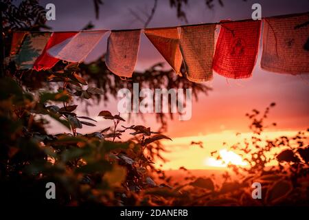 bandiere di preghiera nepalesi che sventolano durante il tramonto Foto Stock