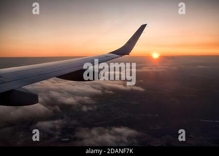 Vista dell'ala dell'aeroplano mentre il sole si alza Foto Stock