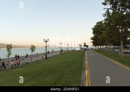 Russia, Novorossiysk, 11 luglio 2020: Terrapieno serale dell'ammiraglio Serebryakov della città del mare nero. I cittadini e gli ospiti si rilassano sulle panchine al sole Foto Stock