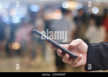 Immagine ravvicinata delle mani dell'uomo con smartphone mobile per la ricerca internet o social network Foto Stock