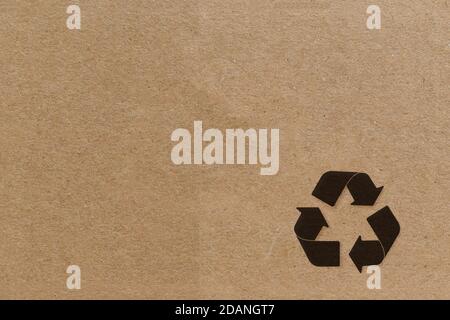 Simbolo di riciclo nero su sfondo di cartone. Foto Stock
